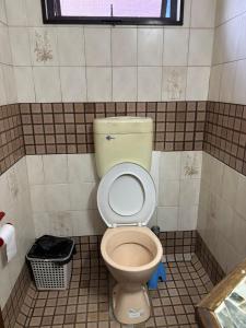a bathroom with a toilet in a tiled room at King Room with Private Bathroom and Free WiFI in SUVA CBD in The Domain