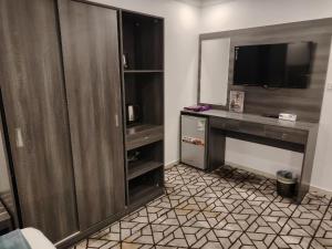 a hotel room with a desk with a tv and a desk at فندق الأولين حياة - النسيم - مكه in Ash Shishah