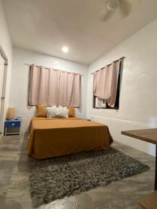 a bedroom with a bed and a window and a rug at Big Fun Beach House in Bacong