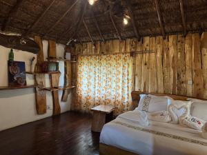 una camera da letto con un letto e una parete di legno di Podocarpus Cottages -02 a Naro Moru