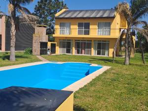 a villa with a swimming pool in front of a house at La casa del lago in Oliveros