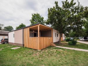 une petite maison avec une porte en bois dans une cour dans l'établissement Lake Serenity Premium Mobile Homes-Two Bedroom, à Mostec