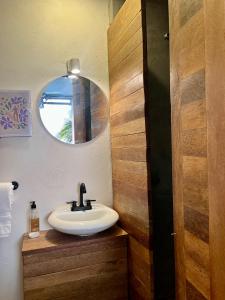 une salle de bain avec un lavabo et un miroir dans l'établissement Over Seas, à Barra de Potosi 21 autres photos