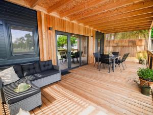 une véranda avec un canapé et une table dans l'établissement Three Bedroom Mobile Home, à Mostec