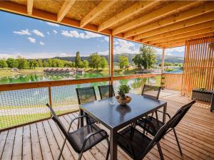 - une table et des chaises sur une terrasse avec vue sur la rivière dans l'établissement Three Bedroom Mobile Home, à Mostec