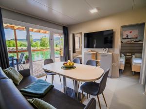 un salon avec une table et un canapé dans l'établissement Three Bedroom Mobile Home, à Mostec