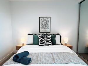 a bedroom with a large bed with two lamps at KozyGuru | Box Hill | Elegant City Hideaway in Box Hill