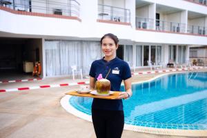 فندق ساندي سبرينغ في باتايا سنترال: امرأة تمسك صينية وعليها كعكة +88 صورة