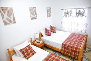 Un dormitorio con dos camas y una ventana. en Joyces Highview, en Kingstown