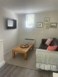 een woonkamer met een bank en een salontafel bij The Hut in Russell