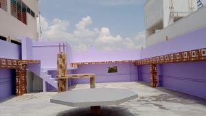 a purple room with a bench and a table at RKGroupStays in Tirupati