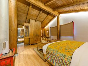 une chambre avec un grand lit dans une pièce dans l'établissement Floral Hotel Shegadan Manor, à Shangri-La