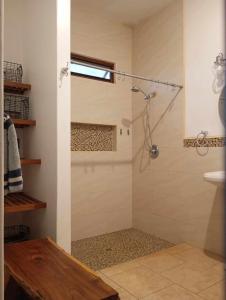 Un baño con ducha con puerta de cristal en Van Kouwenhoven Hostel, en Diriamba 23 fotos más