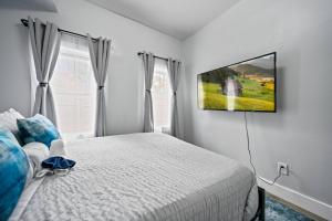 a bedroom with a bed and a tv on the wall at Newly renovated luxury 3BR Condo! 30 mins to NYC in Bergen