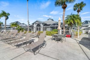 a patio with chairs and tables and palm trees at Bayside Escape - 1345 in Siesta Key
