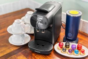 Eine Kaffeemaschine steht mit Cupcakes auf einem Holztisch. in der Unterkunft Deppers Bridge, 3 Bedroom Property 