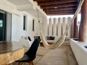 un hamac dans un salon avec une table et des chaises dans l'établissement Casa Sta Margarita, à Zihuatanejo