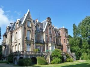a large house on a hill with trees and grass at Appartement atypique sous les toits avec parking - FR-1-712-95 in Villers-sur-Mer