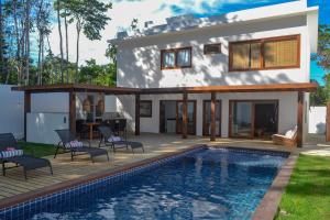 a villa with a swimming pool and a house at Casa Marah - Trancoso in Trancoso