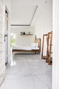 a living room with a bed and a tiled floor at Canggu apartments in Canggu