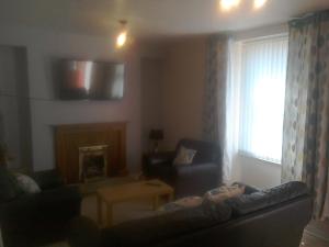 ein Wohnzimmer mit Couch und Kamin in der Unterkunft 17 The Green Holiday Apartment in Tenby