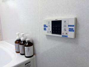 Drei Flaschen ätherischer Öle stehen auf einer Ablage neben einem Waschbecken. in der Unterkunft Sakura House サクラハウス 高知駅から車で20分-豊かな自然を味わう山の隠れ家 in Kōchi