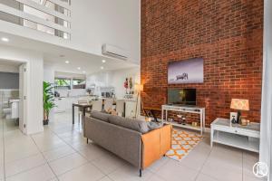 a living room with a brick wall at Norwood Urban Sanctuary Condo 2b1b free parking in Norwood +6 photos
