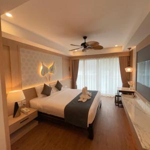 Un dormitorio con una cama con un animal de peluche encima. en Baan Sailom Hotel Phuket - Sha Extra Plus, en Karon Beach