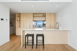 黄金海岸NEW Luxury Coastal Retreat! Palm Beach的厨房配有柜台和2个酒吧凳