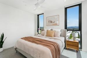 黄金海岸NEW Luxury Coastal Retreat! Palm Beach的白色卧室设有床和大窗户