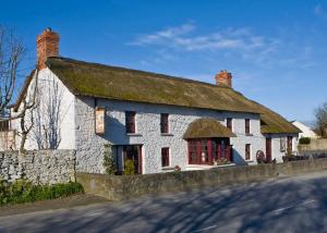 a large white building with a grass roof at The Loft, Ardfert in Ard Fhearta