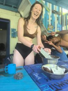 カプルガナにあるLa Bohemia Capurganáのビキニを着てテーブルで食事を準備している女性