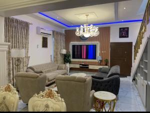 a living room filled with furniture and a chandelier at AlphaDreams Villa in Magodo