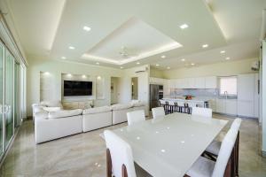 ein großes Wohnzimmer mit einem weißen Tisch und Stühlen in der Unterkunft Ocean View Oasis Infinity Pool in Gated Resort in Coco