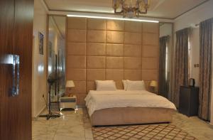 une chambre avec un grand lit et un grand mur dans l'établissement AlphaDreams Villa, à Magodo 84 autres photos
