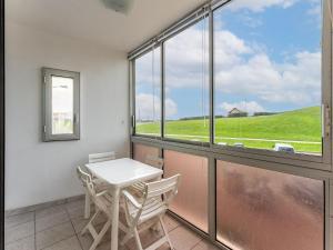 Studio cabine en front de mer avec loggia fermée et parking, 4 pers. - FR-1-521-266 في بيسكاروس-بلاج: طاولة وكراسي في غرفة بها نافذة +صورتان