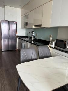 una cucina con tavolo e frigorifero in acciaio inox di Tòa nhà SHP 12 Lạch Tray, tầng 2209 a Hai Phong