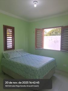 a bedroom with a bed and two windows at Casa Canoa Aracati in Aracati