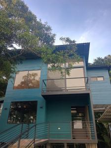 Tamara Monteverde View and Forest Chalet في مونتيفيردي كوستاريكا: البيت الأزرق مع شرفة وأشجار