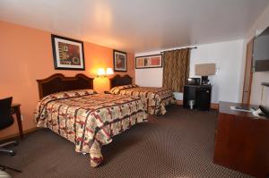 Habitación de hotel con 2 camas y mesa en Williamstown Motel en Williamstown