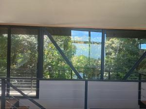 Tamara Monteverde View and Forest Chalet في مونتيفيردي كوستاريكا: غرفة بها نوافذ وإطلالة على الأشجار +7 صور
