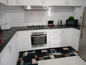 a kitchen with white cabinets and a stove top oven at Kulae Homestay in Nadi