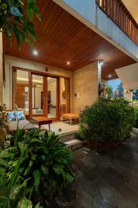 Una sala de estar con un sofá y algunas plantas. en Narada House Ubud, en Ubud