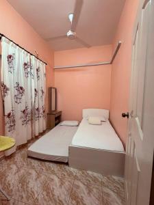 a bedroom with a bed and a door with curtains at Saaidah Homestay in Pendang