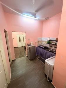 a room with a pink room with a toilet in it at Saaidah Homestay in Pendang
