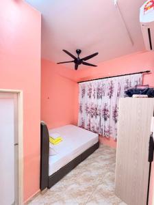a bedroom with a bed and a ceiling fan at Saaidah Homestay in Pendang