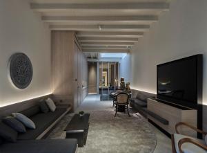 Una sala de estar con un sofá y un televisor en Soori Penang, en George Town