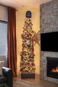 uma árvore de Natal numa sala de estar com lareira em Adora in the Pines with Axe Throwing em Flagstaff