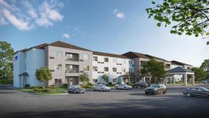 Un edificio con coches aparcados en un estacionamiento. en Comfort Inn & Suites Bethlehem Lehigh Valley Airport, en Bethlehem