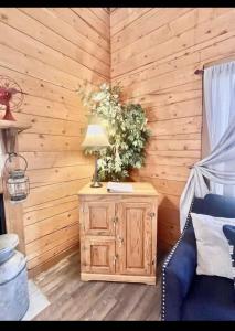 una camera con una parete in legno e un tavolo con una lampada di Enchanted Farmhouse Cabin a Branson